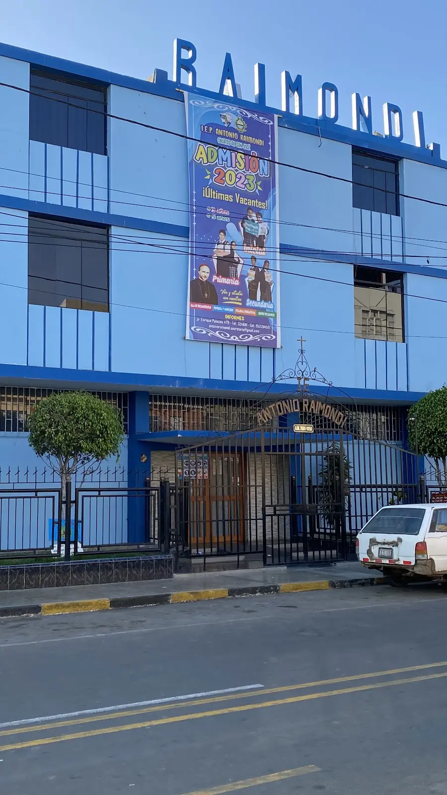 Fachada azul de la I.E.P. Antonio Raimondi con banner de admisión 2023