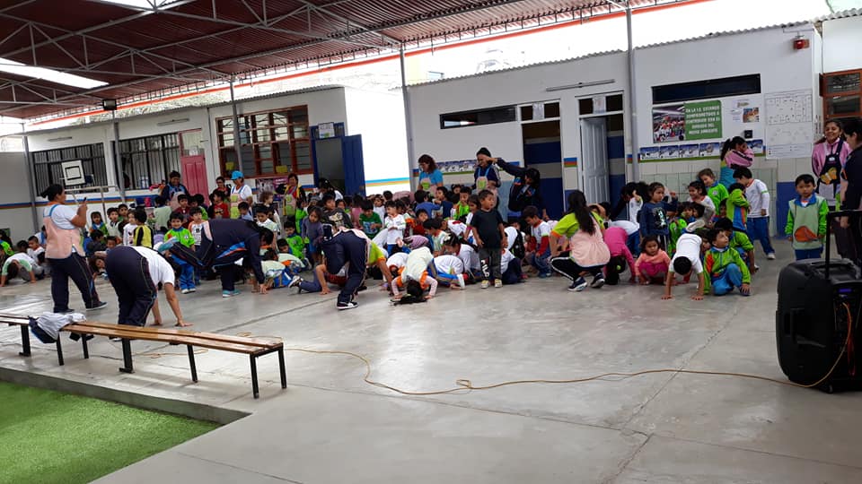 Niños y docentes del colegio Cristo Rey de Chimbote en simulacro de sismo bajo el patio techado.