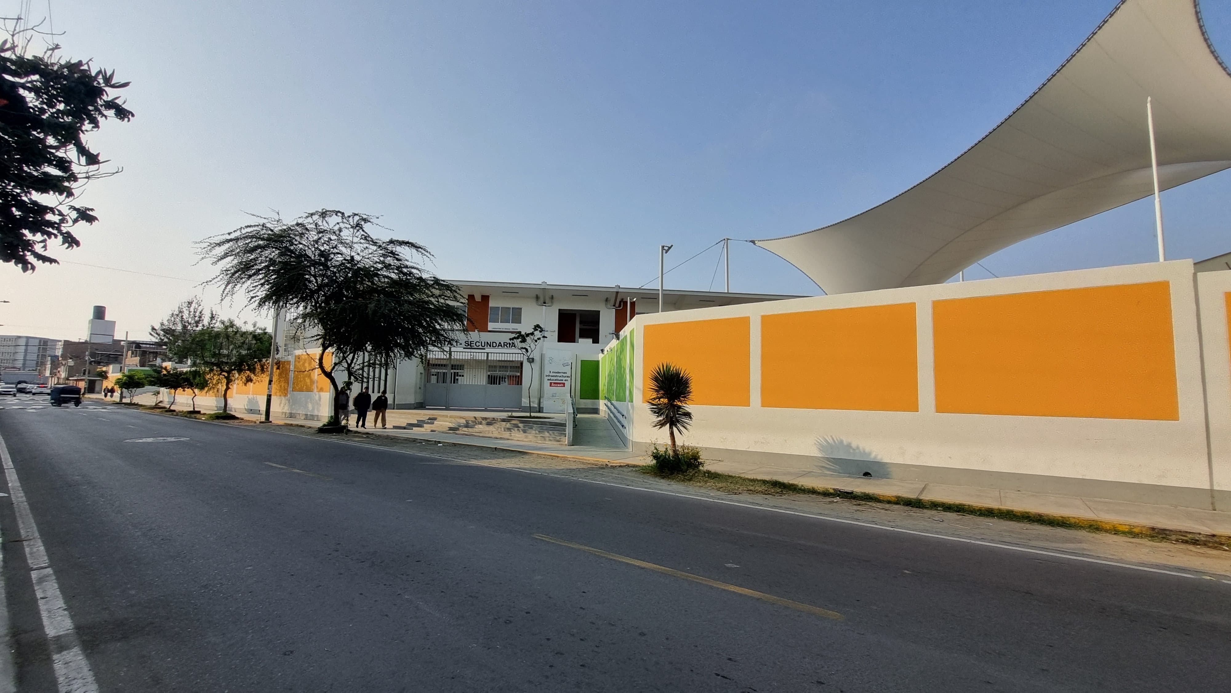 Muro perimetral naranja y techo de membrana tensada del local nuevo del Gastón Vidal Porturas