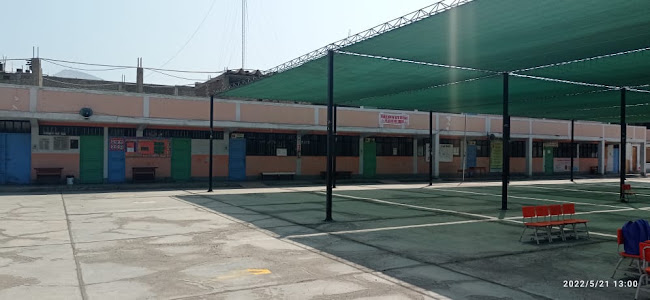 Patio del colegio Manuel González Prada con toldo verde y pabellón naranja