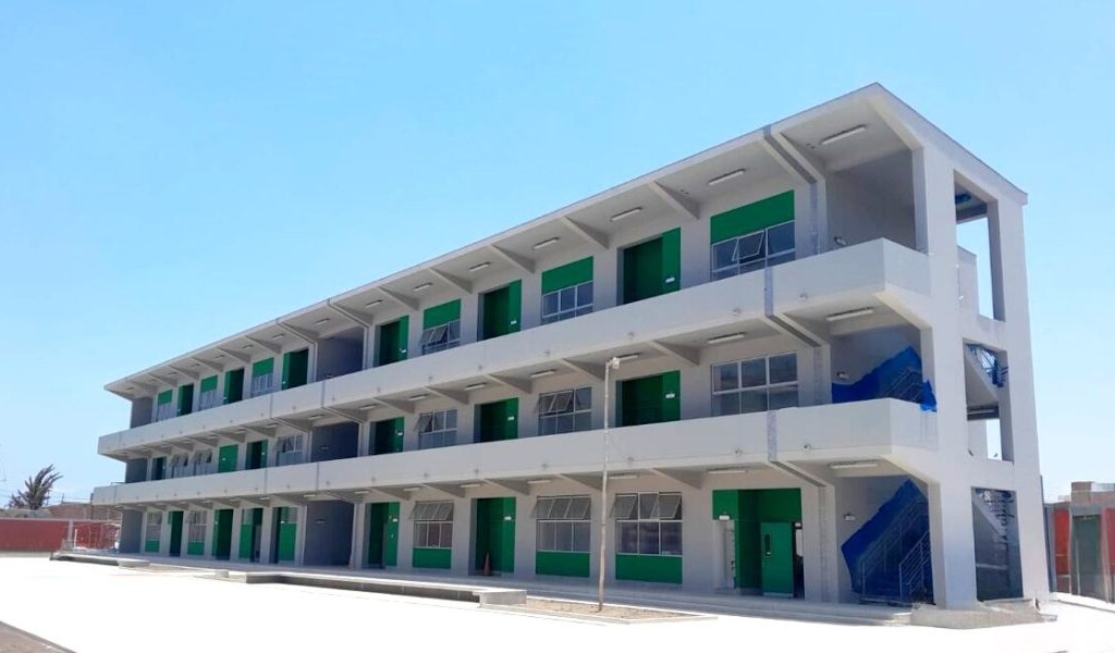 Pabellón nuevo de tres niveles de la I.E. Villa María de Nuevo Chimbote con puertas verdes