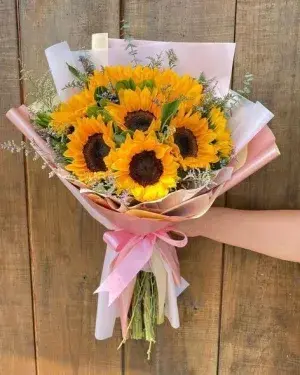 Ramo de girasoles con gypsophila y lazo rosa
