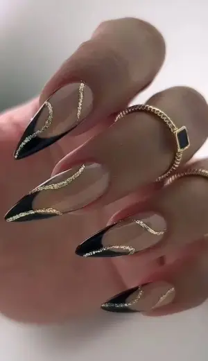 Uñas stiletto negro con filo dorado