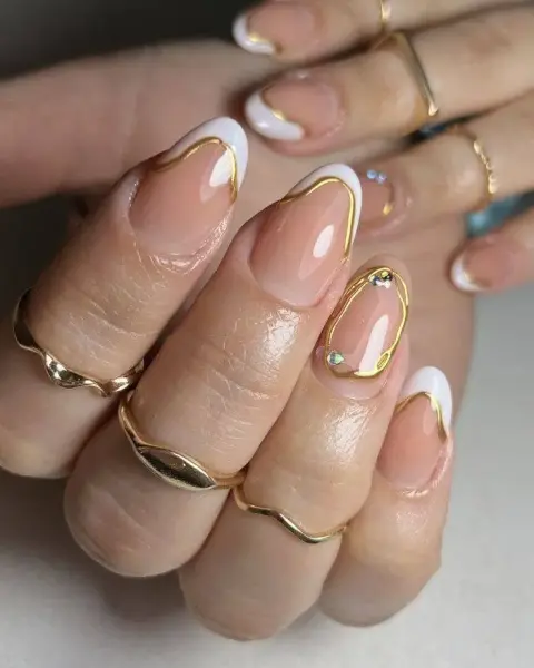 Uñas francesas con línea dorada y pedrería