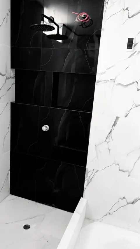 Enchapado de baño moderno con porcelanato tipo mármol blanco y negro