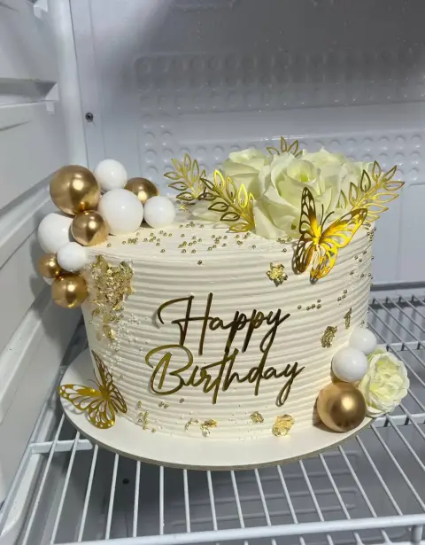 Torta de matrimonio con flores naturales y hojas de oro