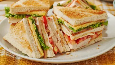 Sándwich club de pollo con papas fritas